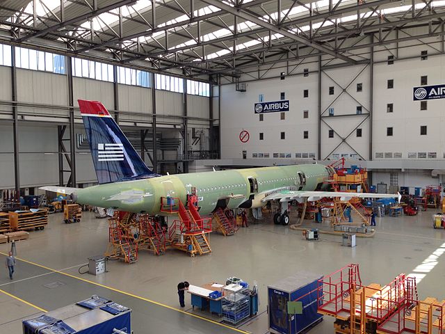 Un dispositif reliant plusieurs canettes de soda découvert dans une usine d'assemblage Airbus site Toulouse Colomiers « US Airways A321 finishing touches (9348772517) » par DearEdward from New York, NY, USA — US Airways A321 finishing touchesUploaded by russavia. Sous licence CC BY 2.0 via Wikimedia Commons.